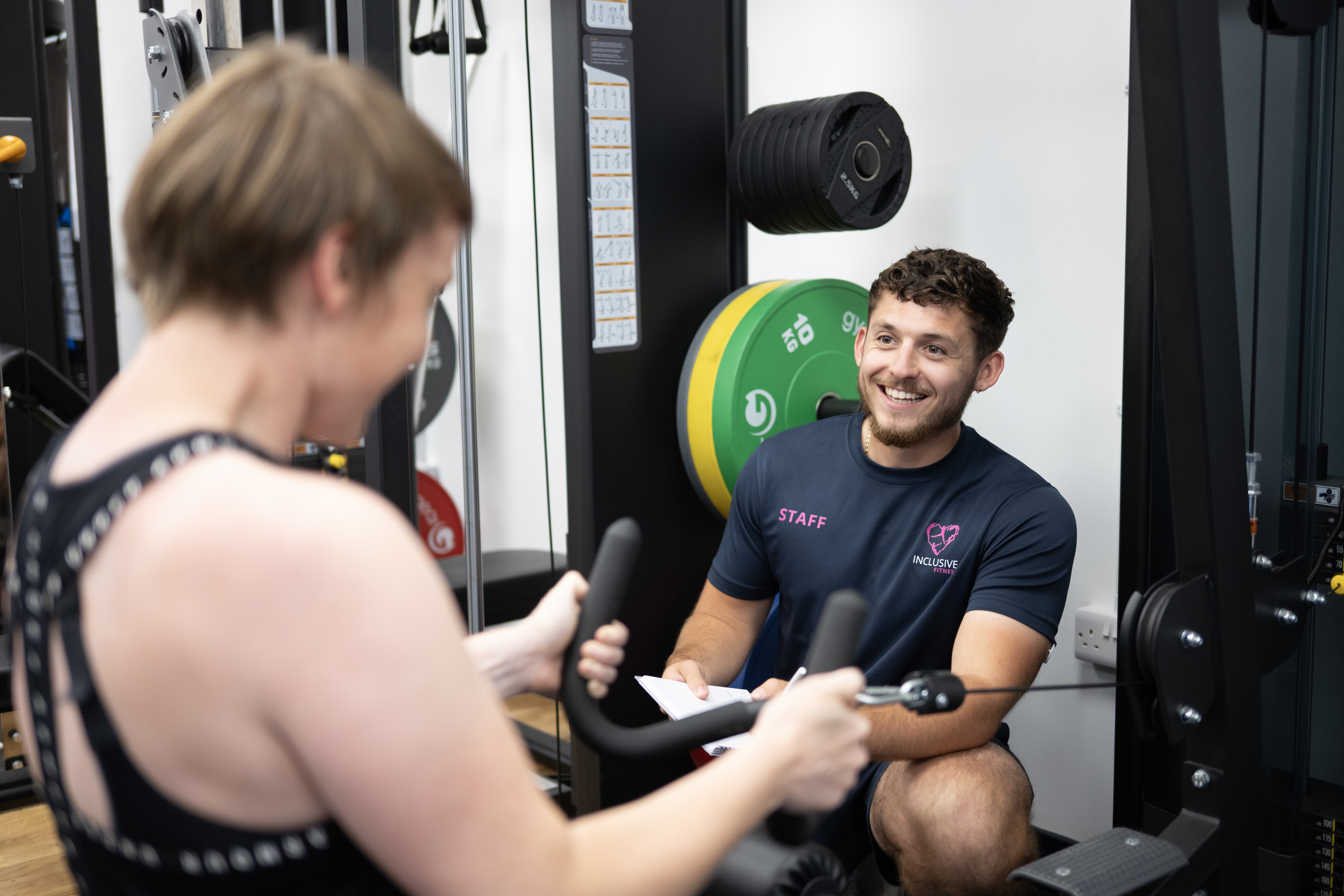 Personal trainer assisting someone with exercise form