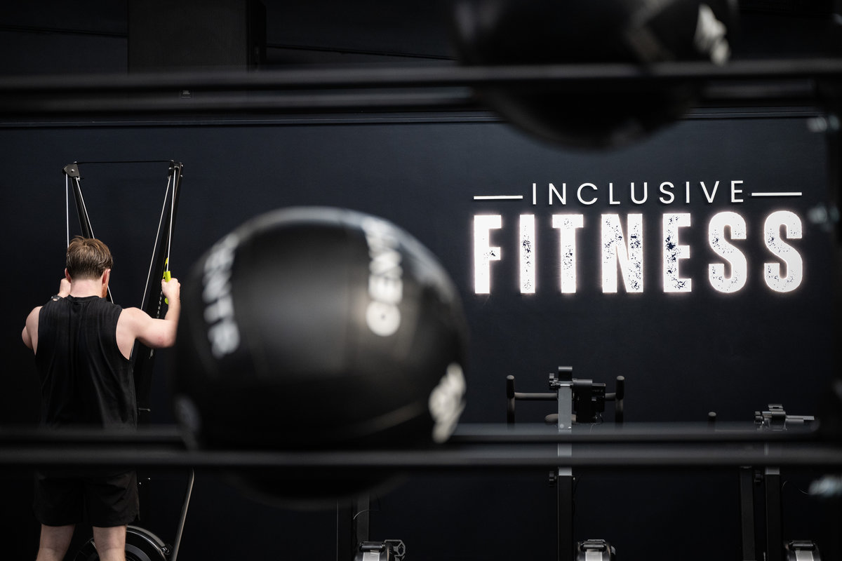 Person working out at Inclusive Fitness with gym branding visible