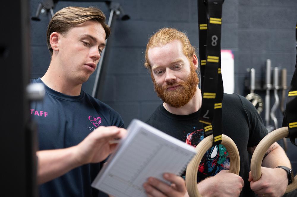 A person starting their fitness journey with a supportive trainer